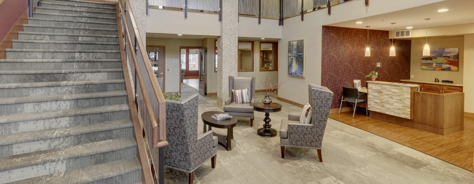 a clubroom with stairs, tables and chairs