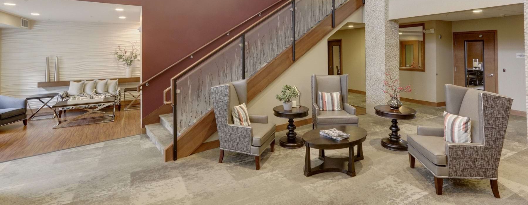 a clubroom with a staircase, tables and chairs