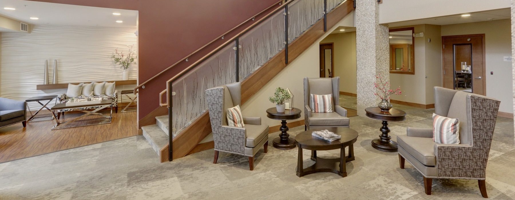 a lobby with tables, chairs and stairs